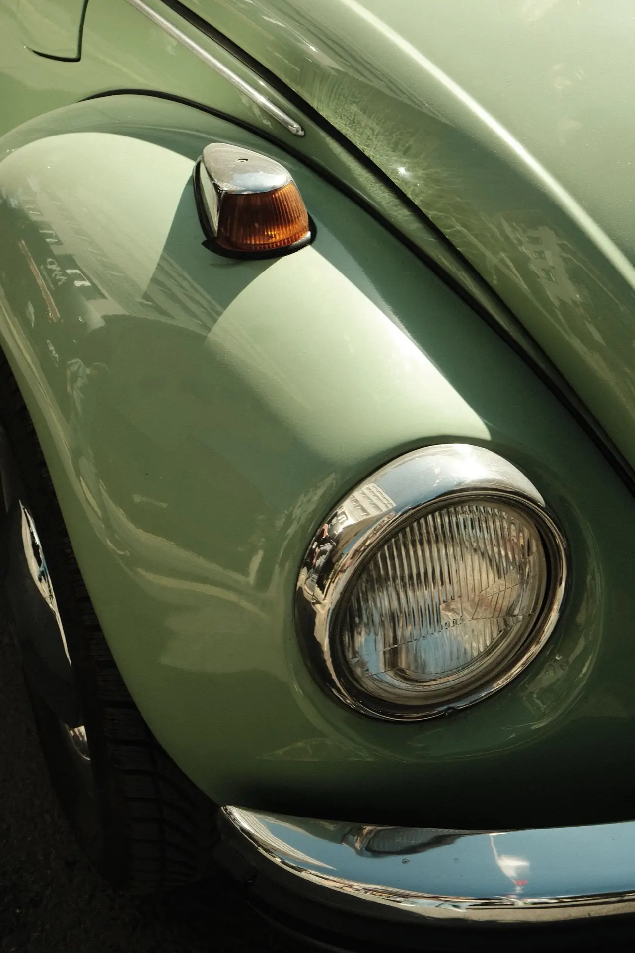Phare rond chromé d'une voiture ancienne vert sauge