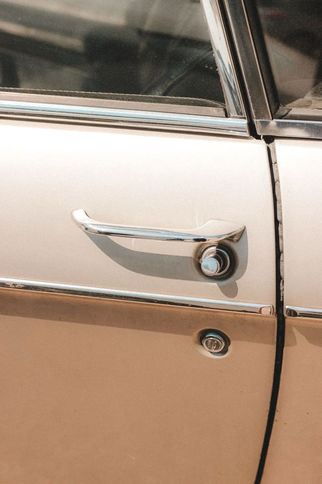 Poignée de porte chromée d'une voiture ancienne beige
